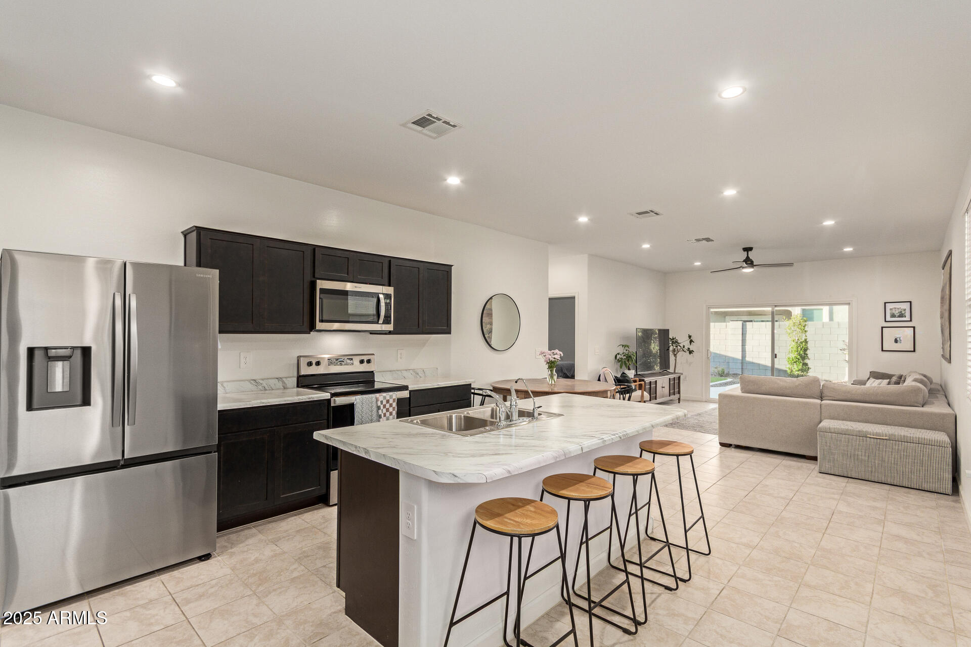 3274 West Stradling Avenue Apache Junction, AZ 85120 - Photo 11 of 35 a kitchen with stainless steel appliances granite countertop a refrigerator and a stove top oven with wooden floor