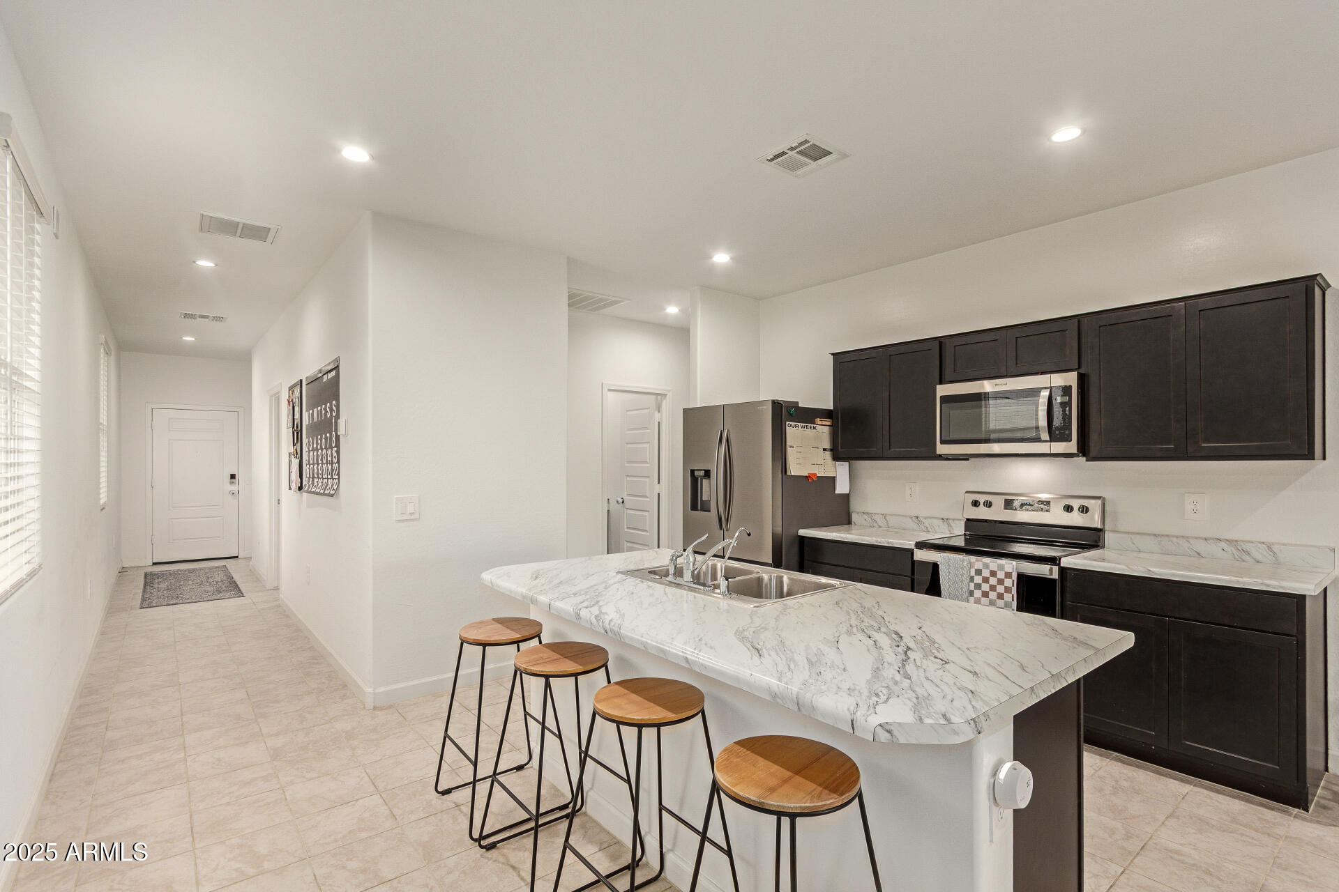 3274 West Stradling Avenue Apache Junction, AZ 85120 - Photo 9 of 35 a kitchen with stainless steel appliances granite countertop a sink a stove a refrigerator with grey cabinets and chairs
