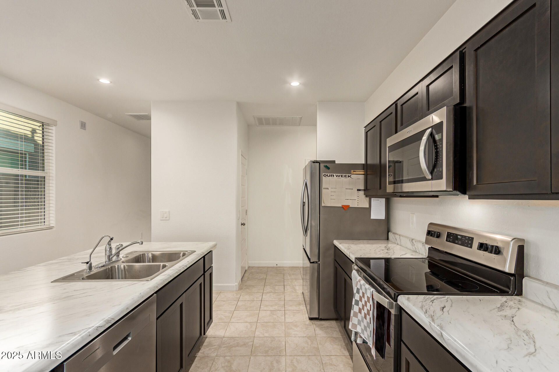 3274 West Stradling Avenue Apache Junction, AZ 85120 - Photo 10 of 35 a kitchen with stainless steel appliances granite countertop a sink stove and refrigerator