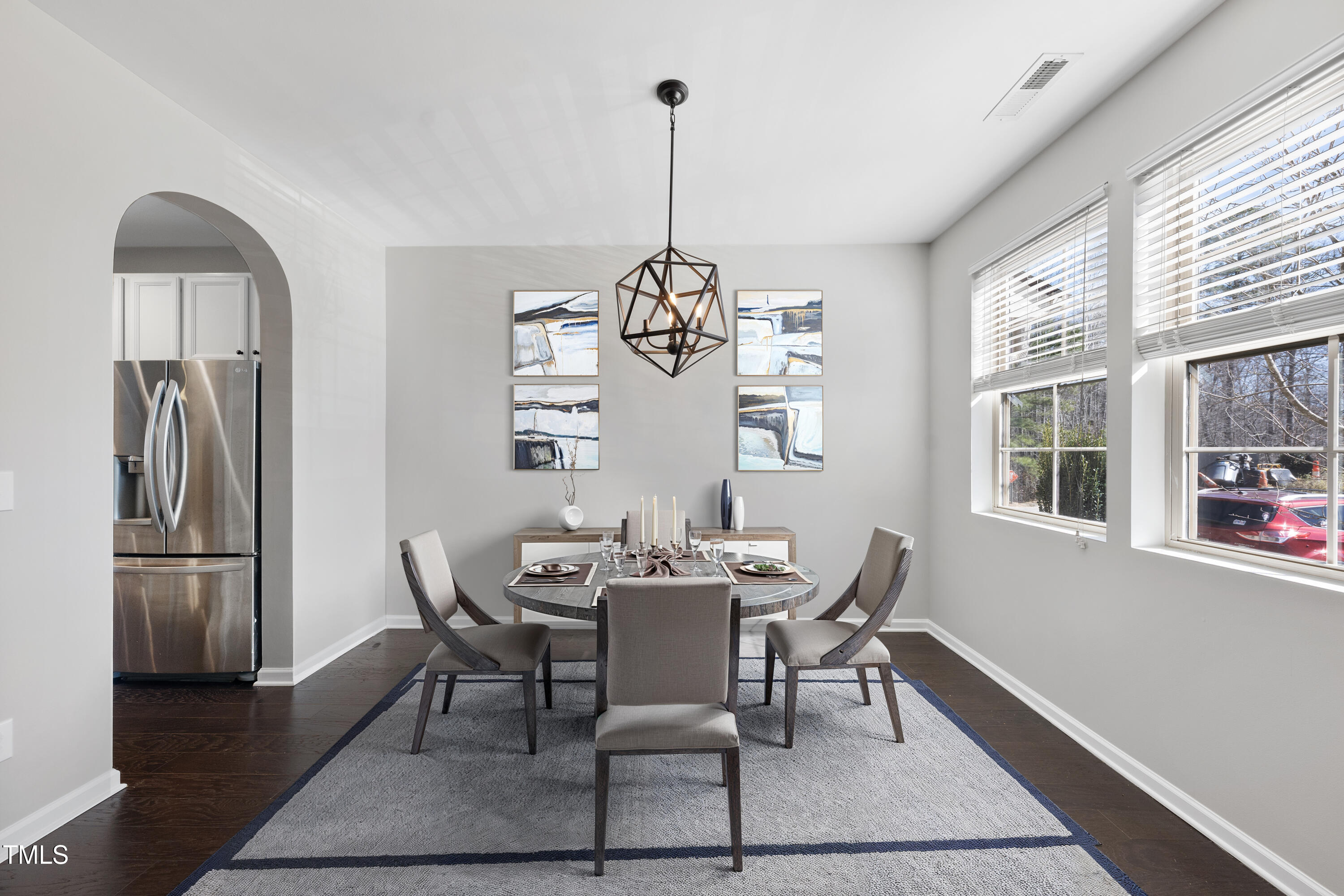 684 Wickham Ridge Road Apex, NC 27539 - Photo 3 of 18 a dining room with furniture a chandelier and wooden floor