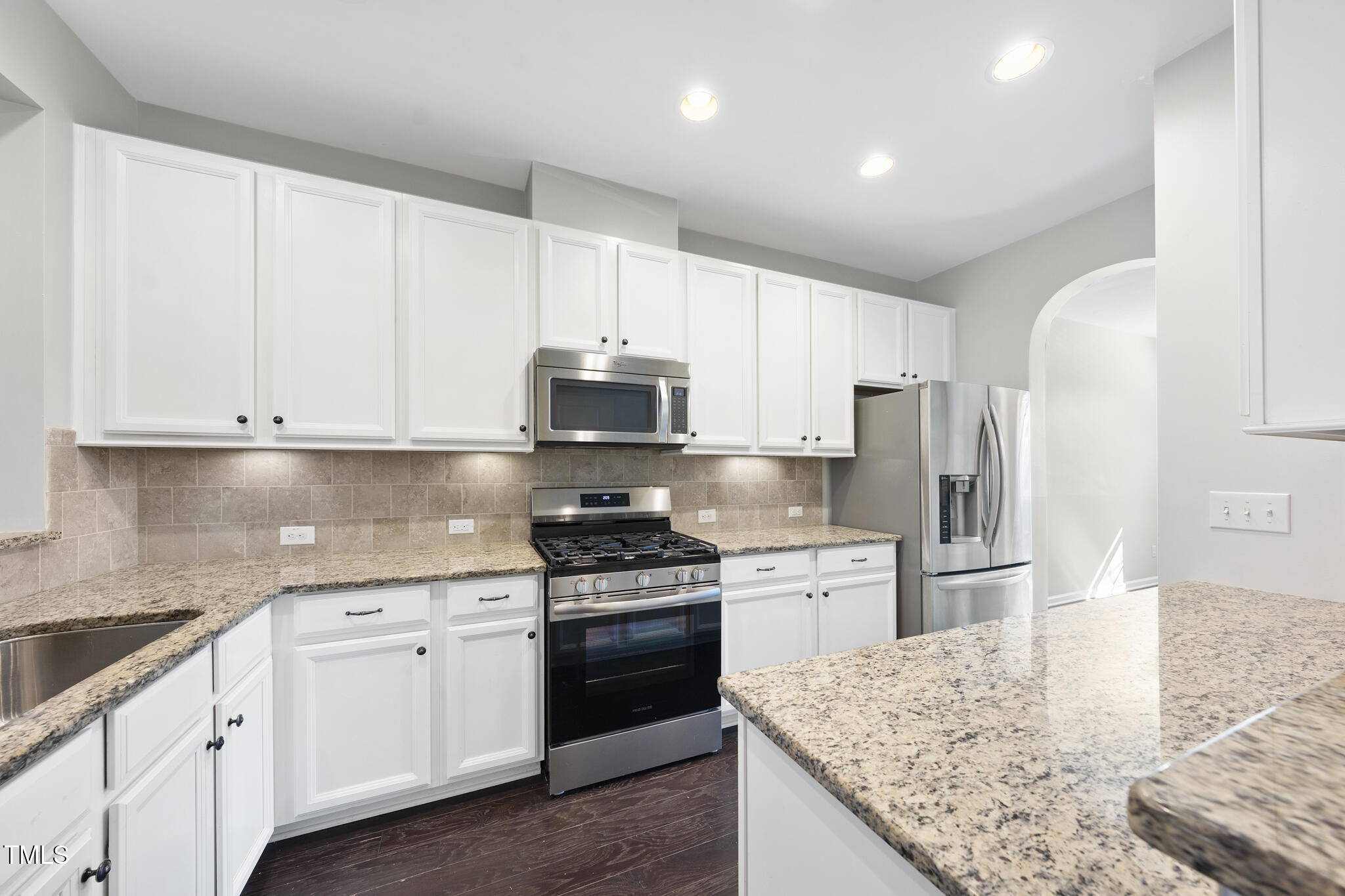 684 Wickham Ridge Road Apex, NC 27539 - Photo 4 of 18 a kitchen with stainless steel appliances white cabinets and a granite counter tops