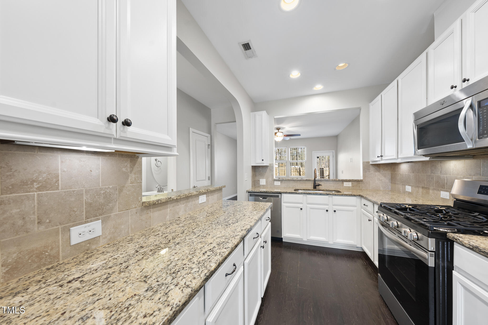 684 Wickham Ridge Road Apex, NC 27539 - Photo 6 of 18 a kitchen with a sink stove top oven and cabinets