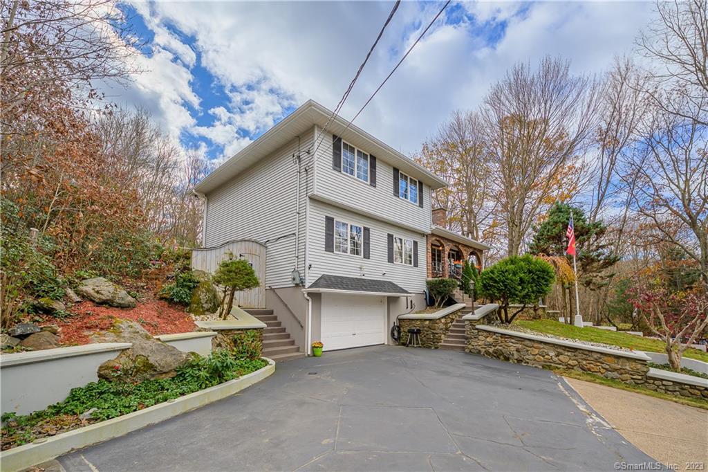 320 Andrews Road Wolcott, CT 06716 - Photo 1 of 1 a front view of a house with a garden and trees