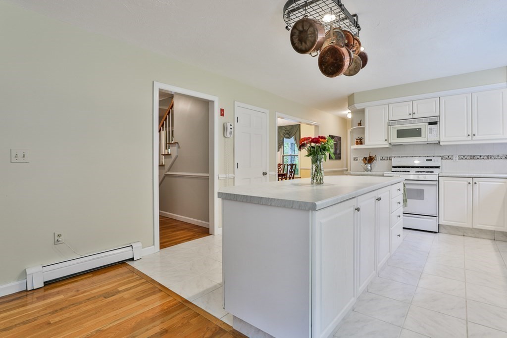 100 Stagecoach Road Lancaster, MA 01523 - Photo 7 of 29 a kitchen with white cabinets and chandelier