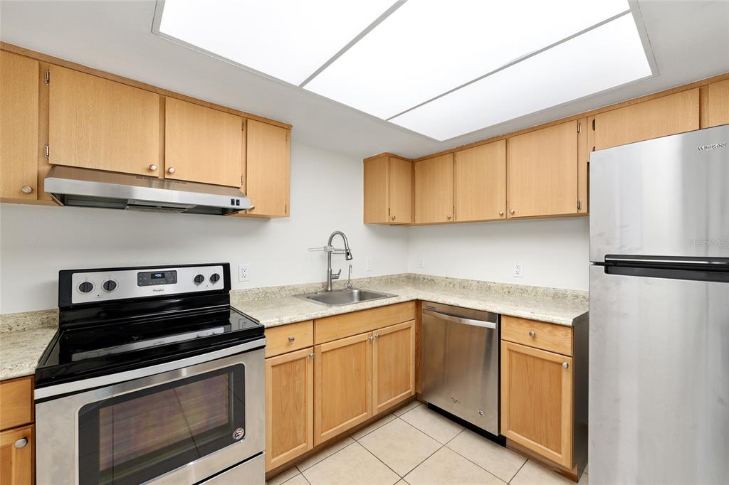 588 Fairways Lane, Unit E101 Ocala, FL 34472 - Photo 11 of 35 a kitchen with stainless steel appliances granite countertop a sink stove and refrigerator