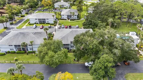 an aerial view of residential houses with outdoor space and trees