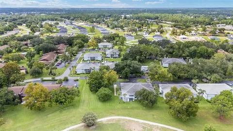 an aerial view of residential house with parking and city view
