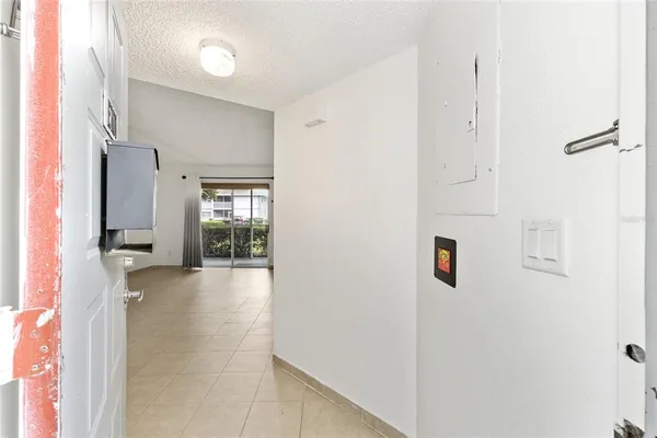 a view of a hallway with wooden floor and cabinet