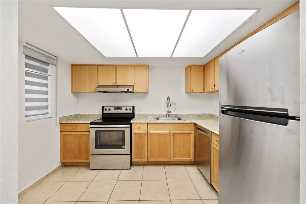 588 Fairways Lane, Unit E101 Ocala, FL 34472 - Photo 10 of 35 a kitchen with a stove a sink and a refrigerator