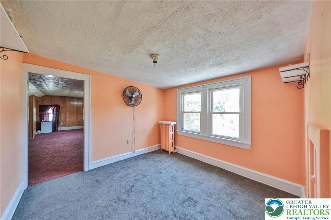 417 3rd Street Lehighton, PA 18235 - Photo 24 of 39 This interior room features twin windows that allow natural light to fill the space, highlighting the textured ceiling.