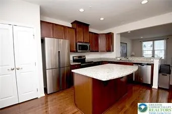 a kitchen with stainless steel appliances granite countertop a refrigerator a sink a stove a microwave and island
