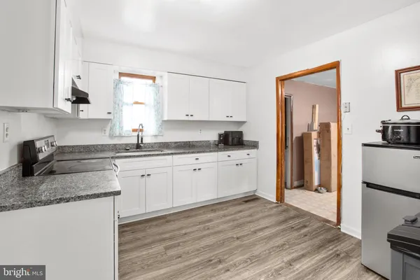 a kitchen with granite countertop a refrigerator sink and cabinets