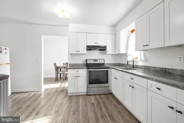 a kitchen with granite countertop white cabinets and white appliances