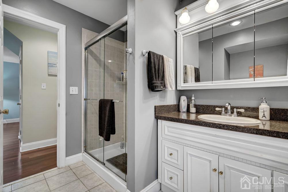 11 Kenmore Road Edison, NJ 08817 - Photo 14 of 40 a bathroom with a granite countertop sink a mirror and shower