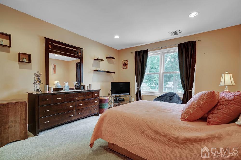 11 Kenmore Road Edison, NJ 08817 - Photo 20 of 40 a bedroom with a bed and a mirror on dresser