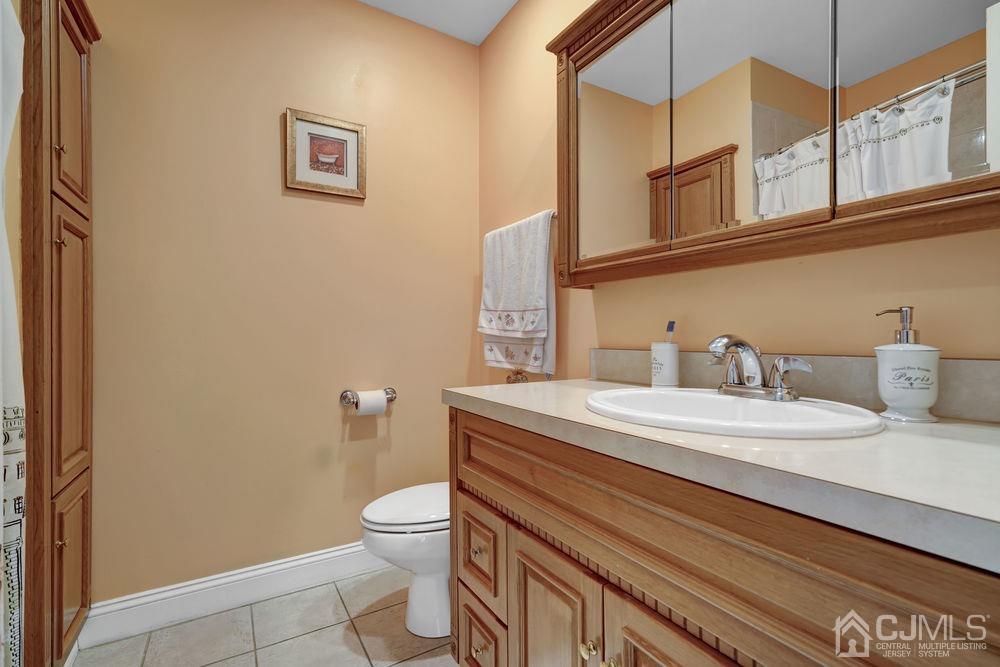11 Kenmore Road Edison, NJ 08817 - Photo 22 of 40 a bathroom with a sink a toilet and a mirror