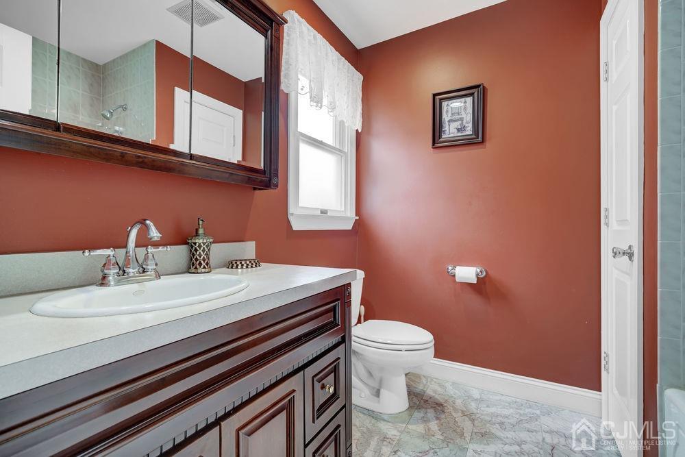11 Kenmore Road Edison, NJ 08817 - Photo 29 of 40 a bathroom with a sink a toilet and mirror