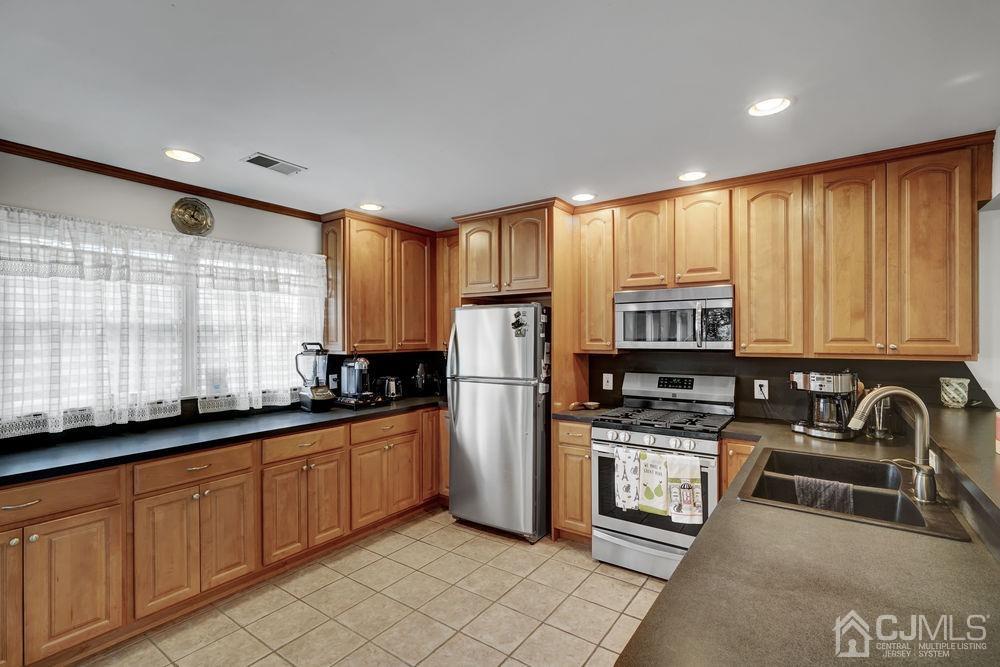 11 Kenmore Road Edison, NJ 08817 - Photo 9 of 40 a kitchen with stainless steel appliances granite countertop a stove a sink and a refrigerator
