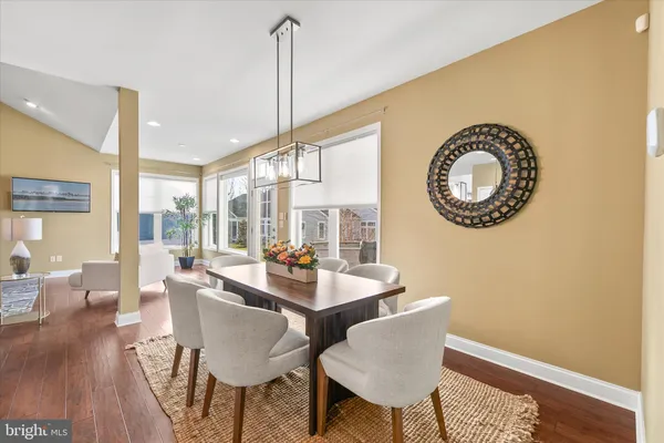 a kitchen with kitchen island granite countertop a refrigerator a stove a sink a dining table and chairs