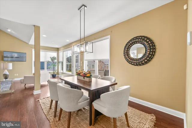 a kitchen with kitchen island granite countertop a refrigerator a stove a sink a dining table and chairs