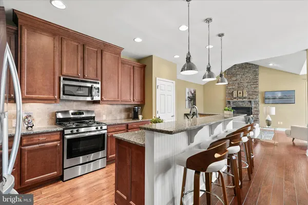 a kitchen with a stove and a wooden floor