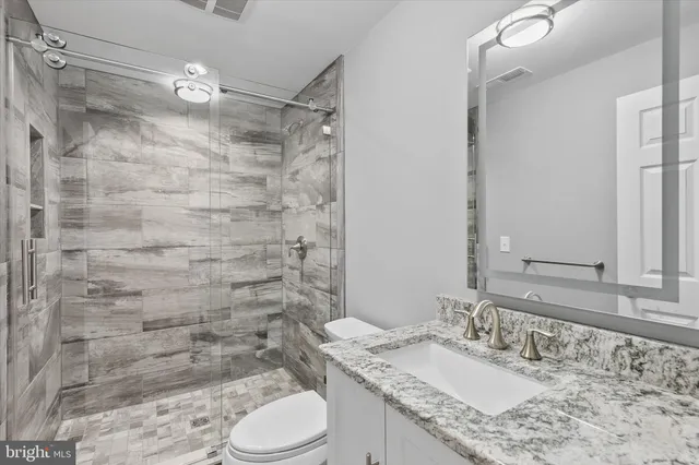 a view of a big room with windows and chandelier fan