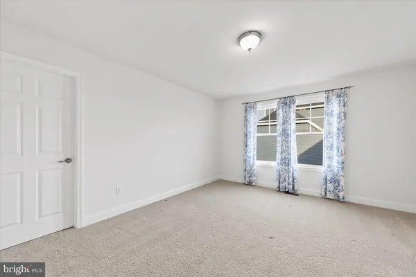 an empty room with windows and painted walls