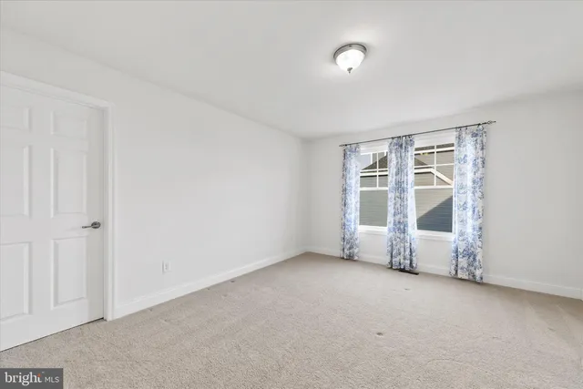 an empty room with windows and painted walls