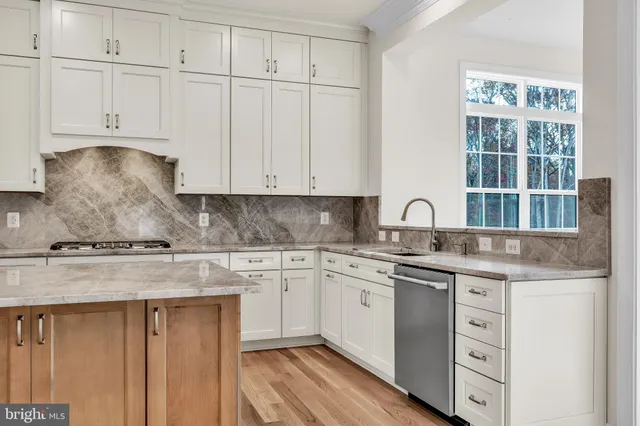 a kitchen with granite countertop white cabinets and sink