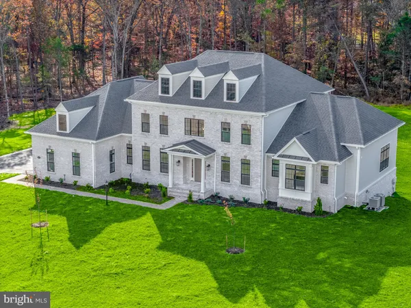 a front view of a house with a garden and trees