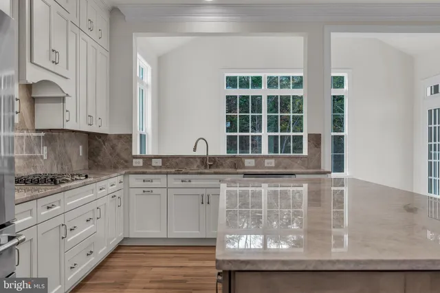 a kitchen with granite countertop a sink stove and cabinets