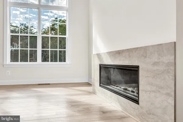 a view of an empty room with a window and fireplace