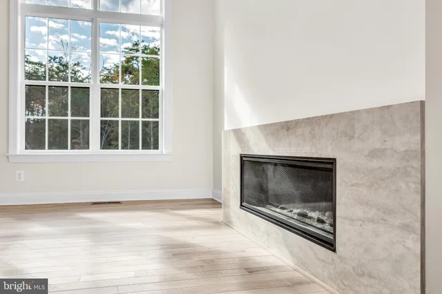 a view of an empty room with a window and fireplace
