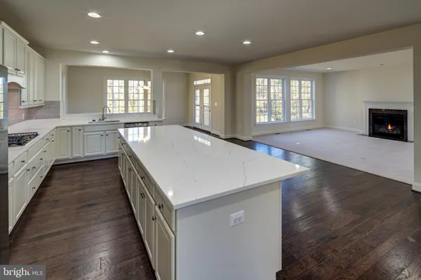 a kitchen with kitchen island granite countertop a sink cabinets and stainless steel appliances