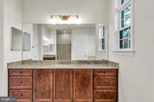 a spacious bathroom with a granite countertop tub sink and mirror