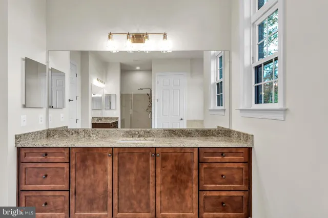a spacious bathroom with a granite countertop tub sink and mirror