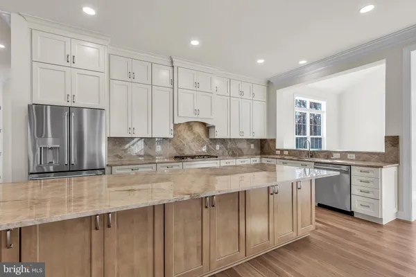 a kitchen with stainless steel appliances granite countertop a stove a sink and a refrigerator