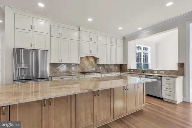 a kitchen with stainless steel appliances granite countertop a stove a sink and a refrigerator