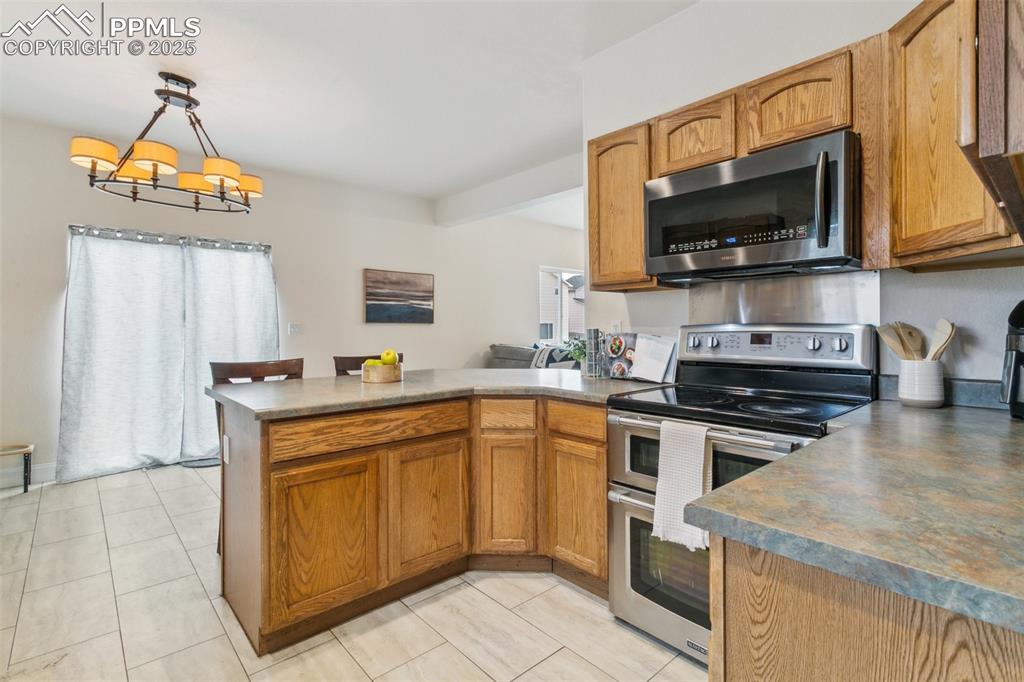 12229 Crystal Downs Road Peyton, CO 80831 - Photo 18 of 47 a kitchen with stainless steel appliances granite countertop a sink and a stove