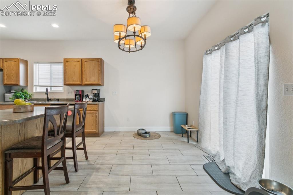 12229 Crystal Downs Road Peyton, CO 80831 - Photo 21 of 47 a view of a dining room with furniture and a chandelier