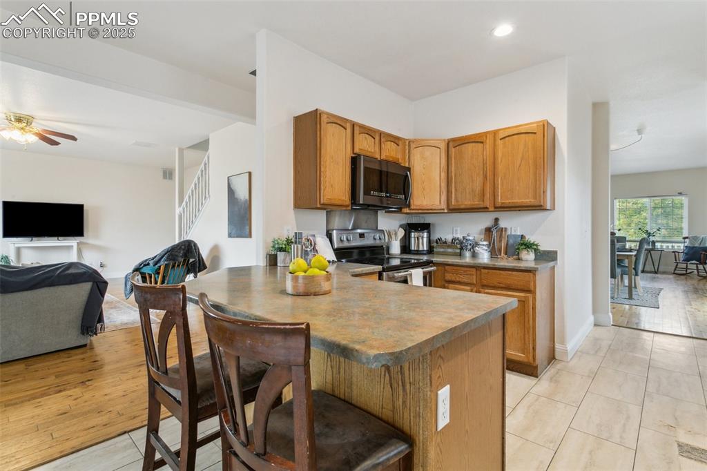 12229 Crystal Downs Road Peyton, CO 80831 - Photo 23 of 47 a kitchen with a table chairs a sink dishwasher stove and cabinets with wooden floor