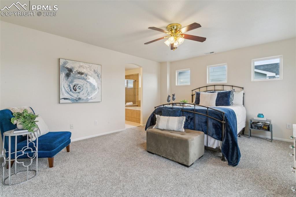 12229 Crystal Downs Road Peyton, CO 80831 - Photo 29 of 47 a bedroom with a bed and a chandelier