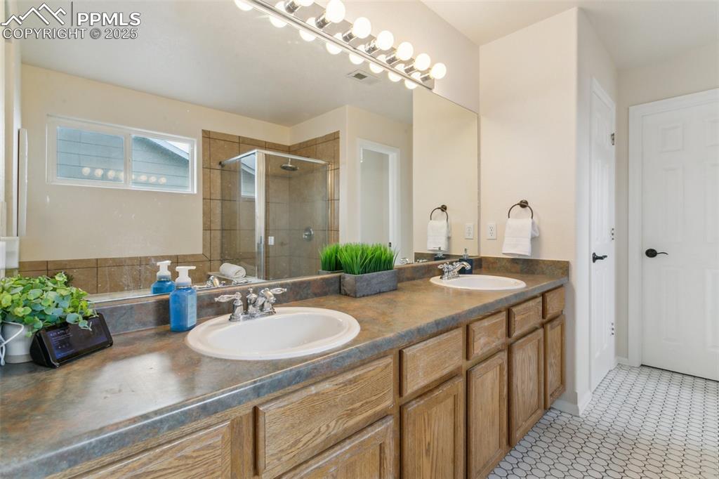12229 Crystal Downs Road Peyton, CO 80831 - Photo 32 of 47 a bathroom with a sink double vanity granite and a mirror
