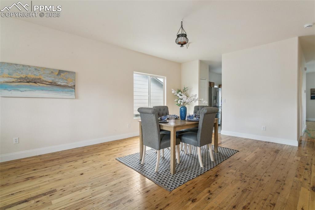 12229 Crystal Downs Road Peyton, CO 80831 - Photo 4 of 47 a view of a dining room with furniture and wooden floor