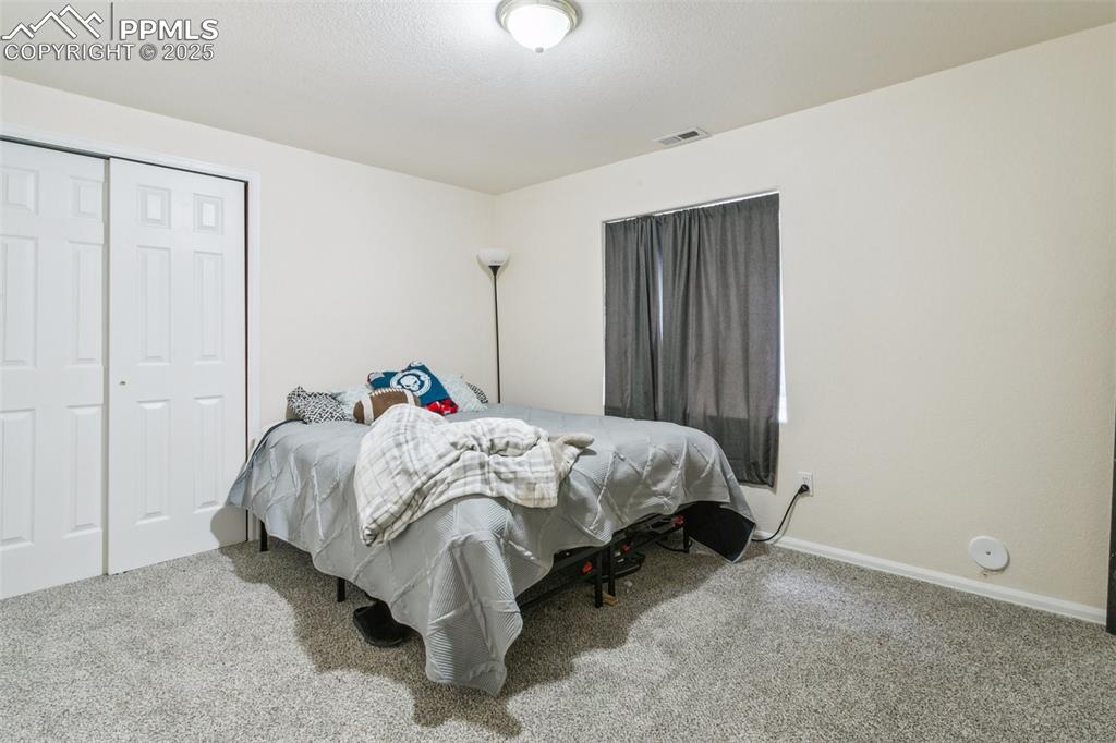 12229 Crystal Downs Road Peyton, CO 80831 - Photo 45 of 47 a bed sitting in a bedroom next to a cabinet