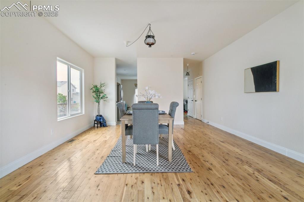 12229 Crystal Downs Road Peyton, CO 80831 - Photo 6 of 47 a dining room with wooden floor and a floor to ceiling window