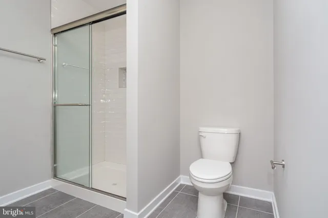 a white toilet sitting next to a shower