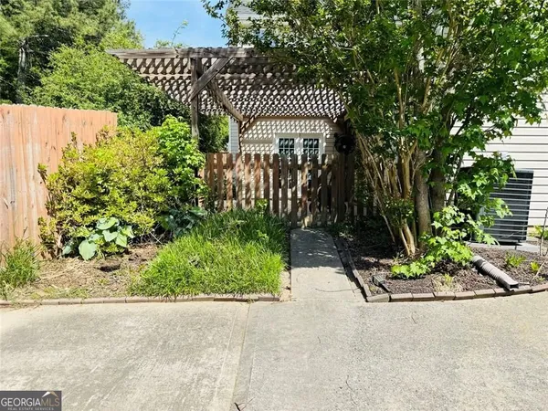 a view of a backyard with potted plants and large tree