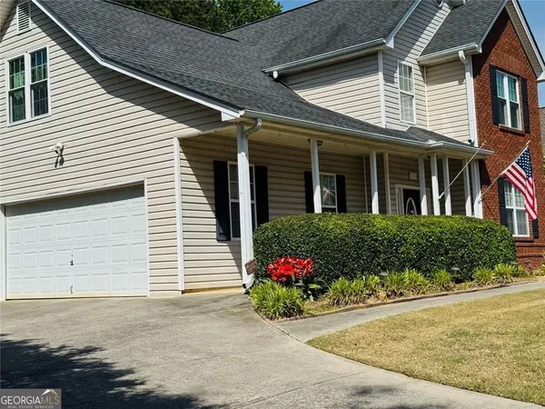 a front view of a house with a yard and potted plants