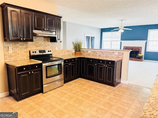 a kitchen with stainless steel appliances granite countertop a stove a sink dishwasher and a refrigerator